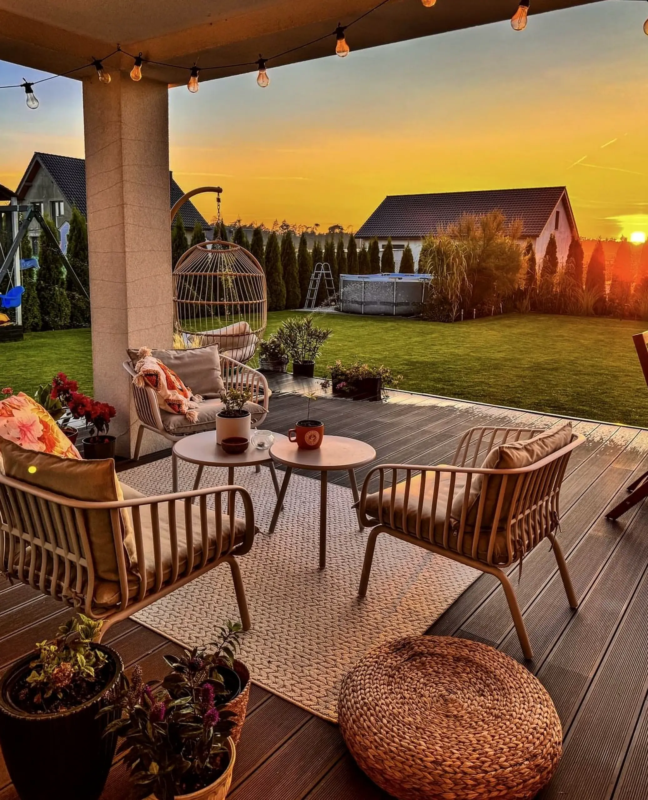 Inviting outdoor lounge anchors the garden edge with charm, giving the view a mood that feels warm without clutter.